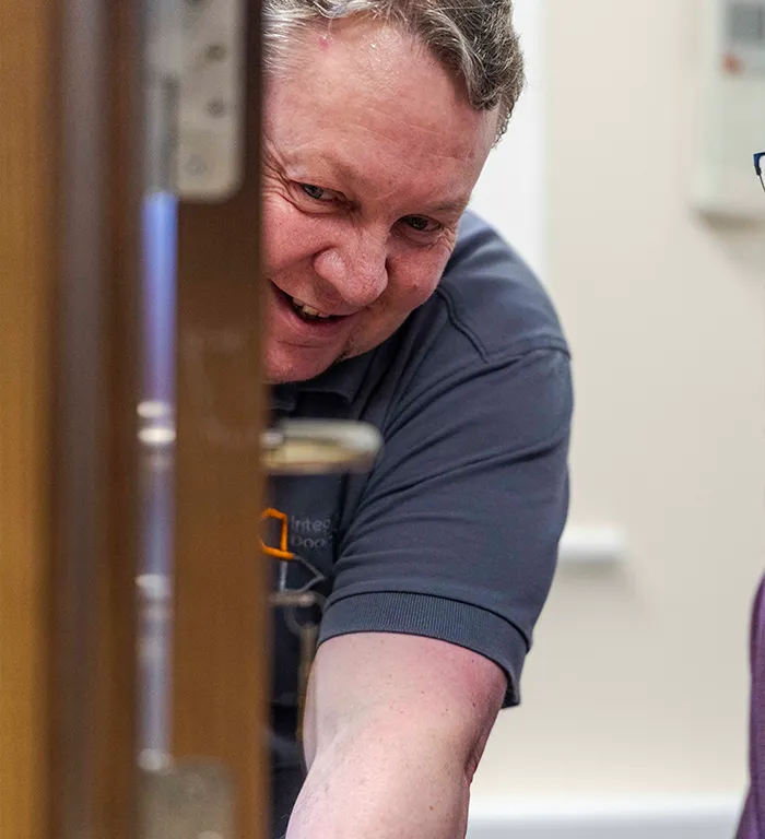 Integrated Doorset member of staff inspecting a door locking mechanism